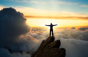 hombre con los brazos abiertos en una montaña sobre las nubes