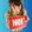 una mujer sujetando un cartel que dice no